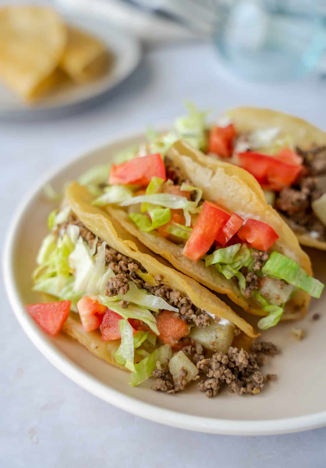 Up close view of crispy Mexican picadillo tacos on a plate.