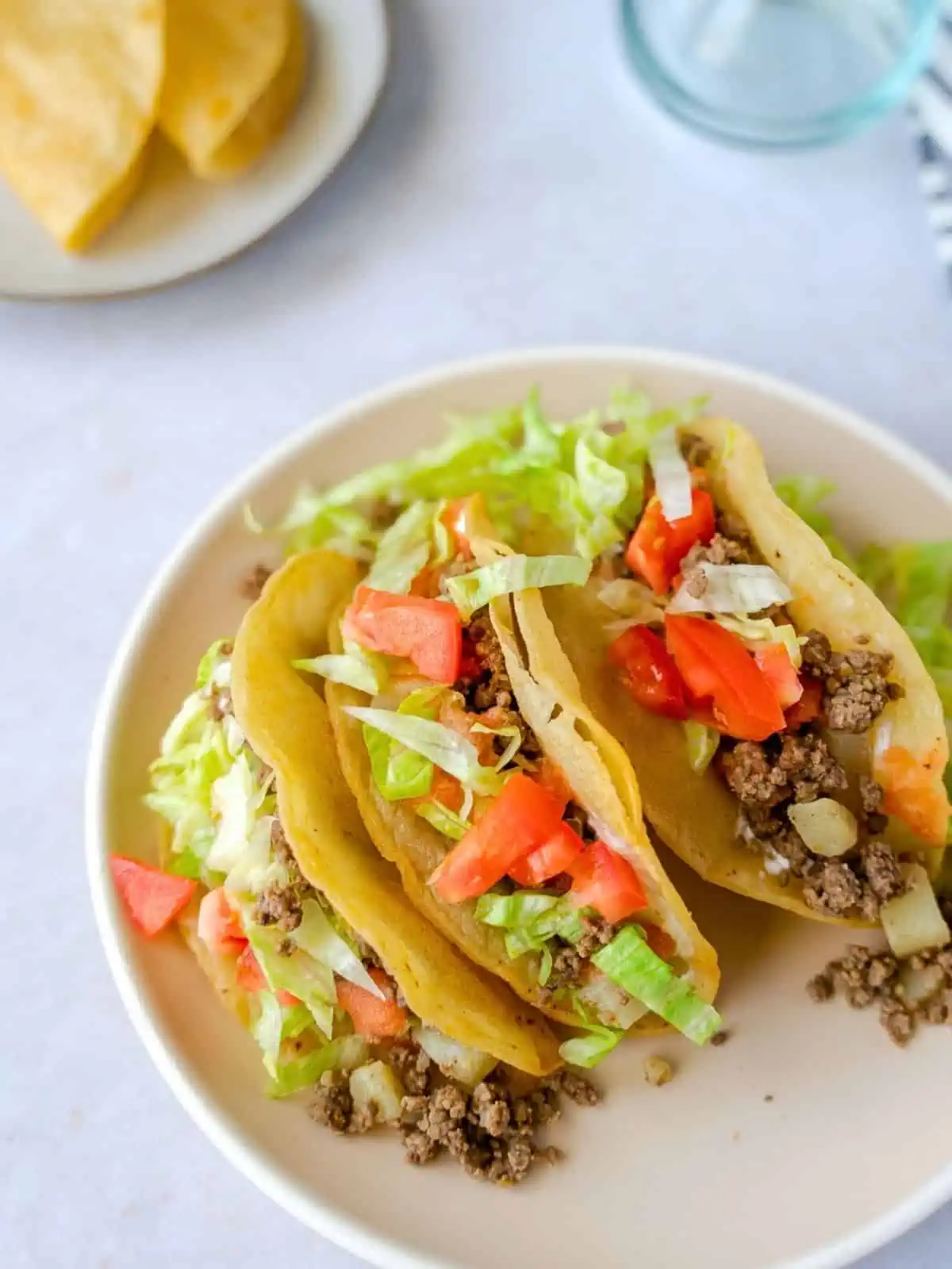 Three crispy Mexican picadillo tacos on a plate.
