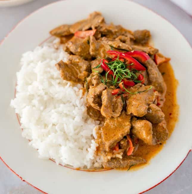 Feature image of Panang beef with rice on a plate.