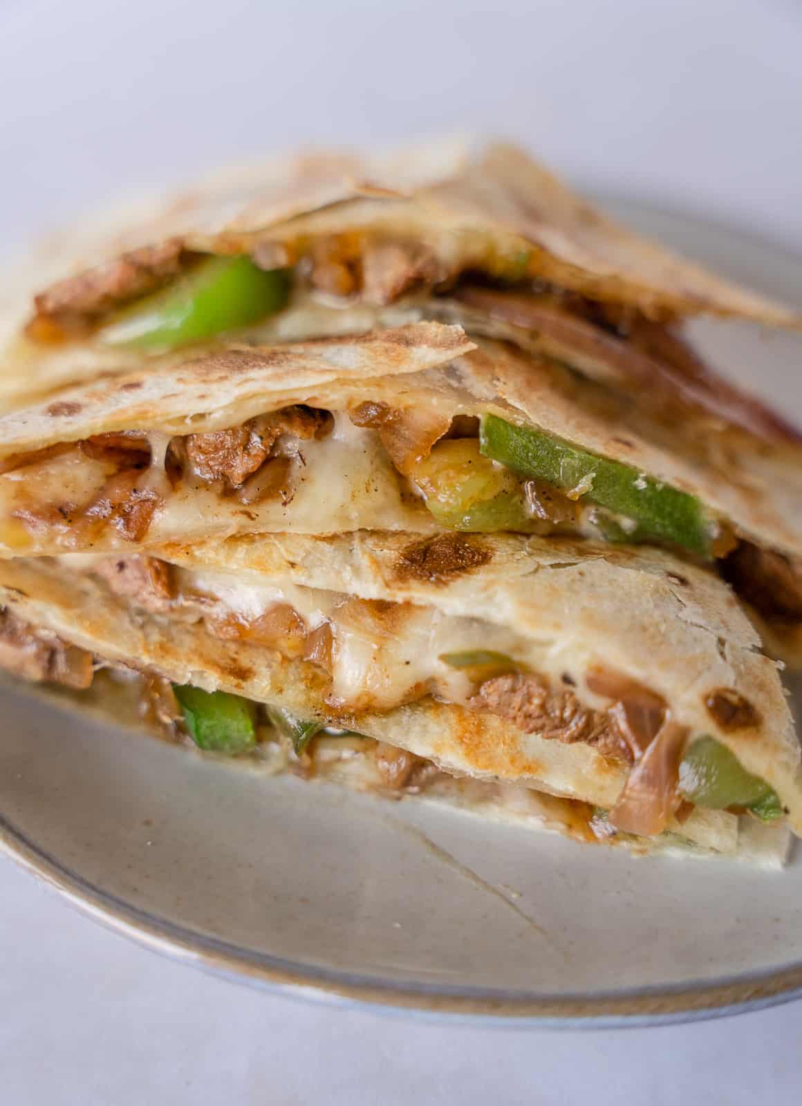 Slice quesadilla stacked together on a plate.