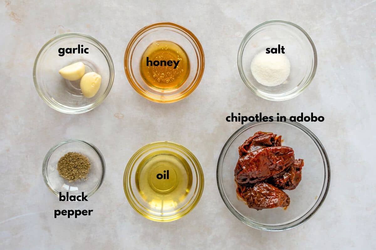 Ingredients for chipotle marinade in individual bowls and labeled with text.