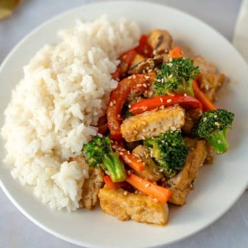 Feature image of teriyaki tofu and vegetable stir fry with a side of rice.