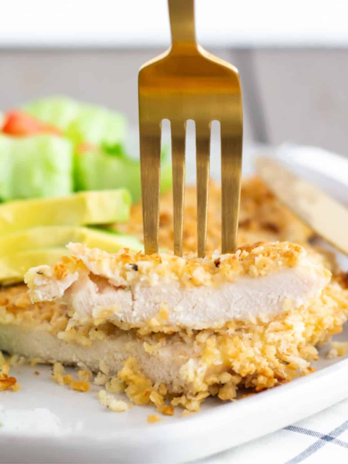 Fork going into sliced stacked chicken milanesa.