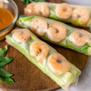 Feature image of shrimp rice paper rolls on a wooden board.