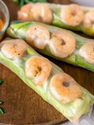 Feature image of shrimp rice paper rolls on a wooden board.