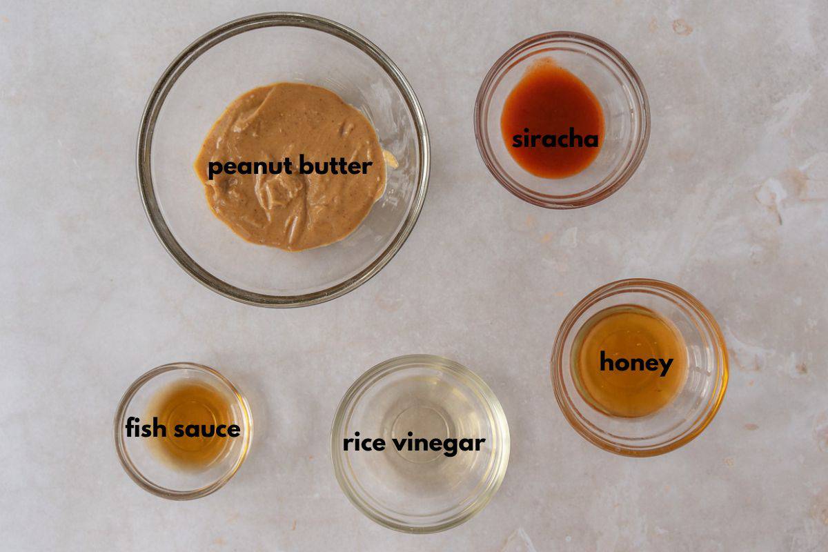 Peanut butter, siracha, fish sauce, rice vinegar, and honey in little bowls.