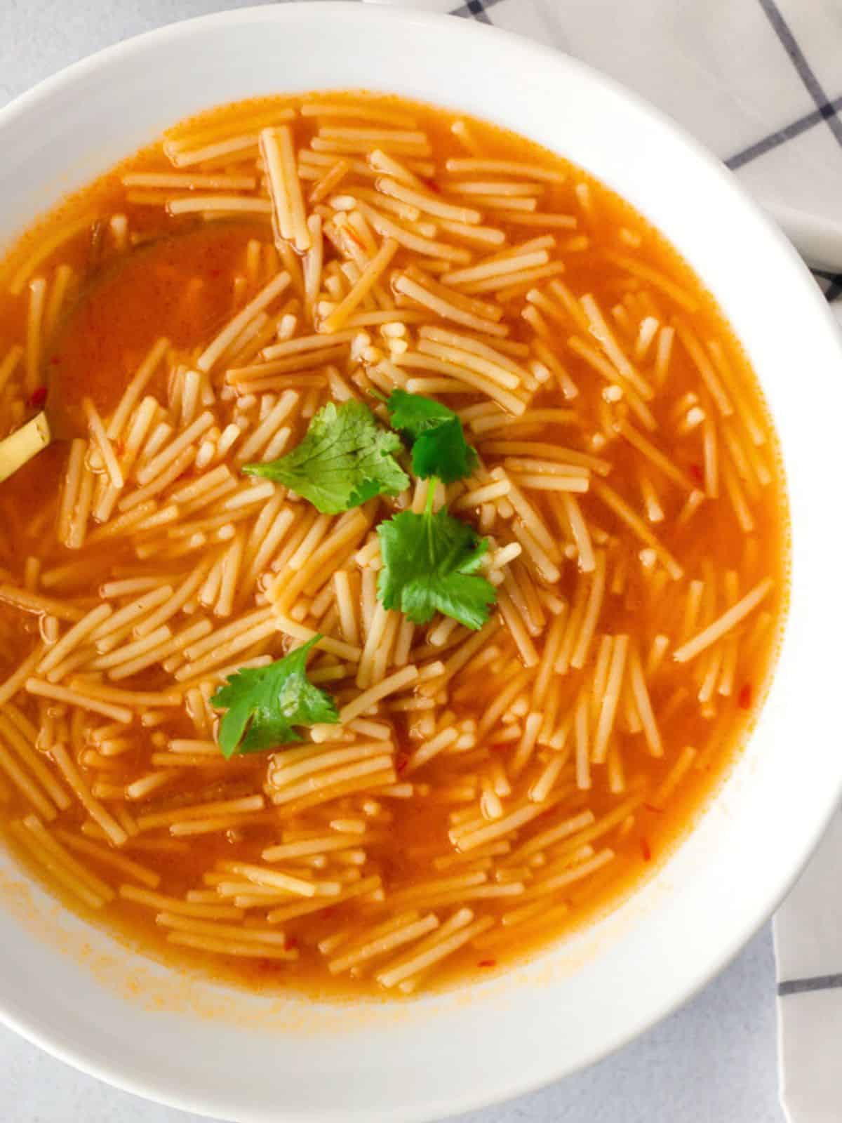 Sopa de Fideo in a white bowl topped with cilantro.