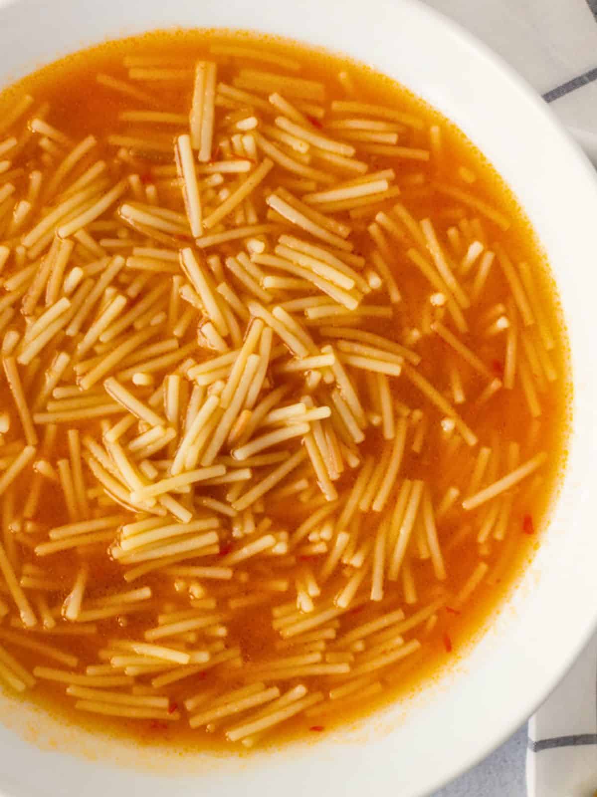 Overhead view of sopita de fideo in a white bowl.