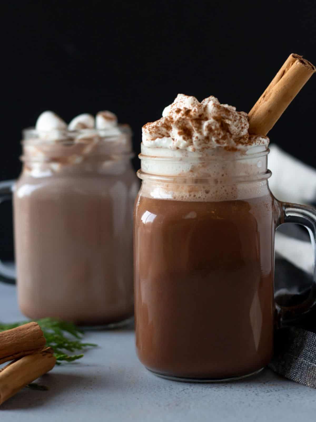 Two glass mugs, one filled with a lighter hot chocolate and one with a darker hot chocolate.
