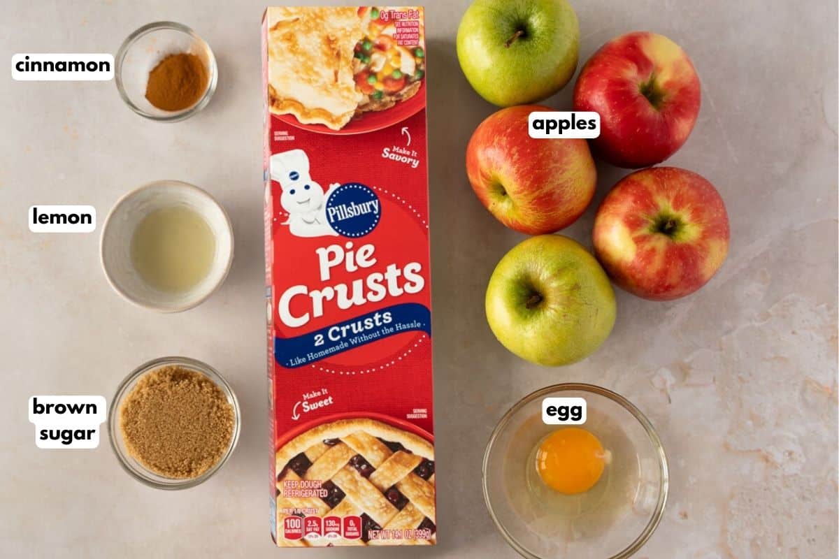 Ingredients with text, cinnamon, lemon, brown sugar, pie crusts, apples, and an egg.