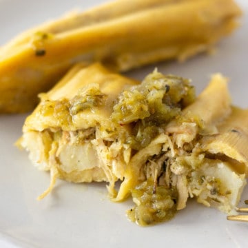 Up close view of chicken tamale cut in half with filling visible.