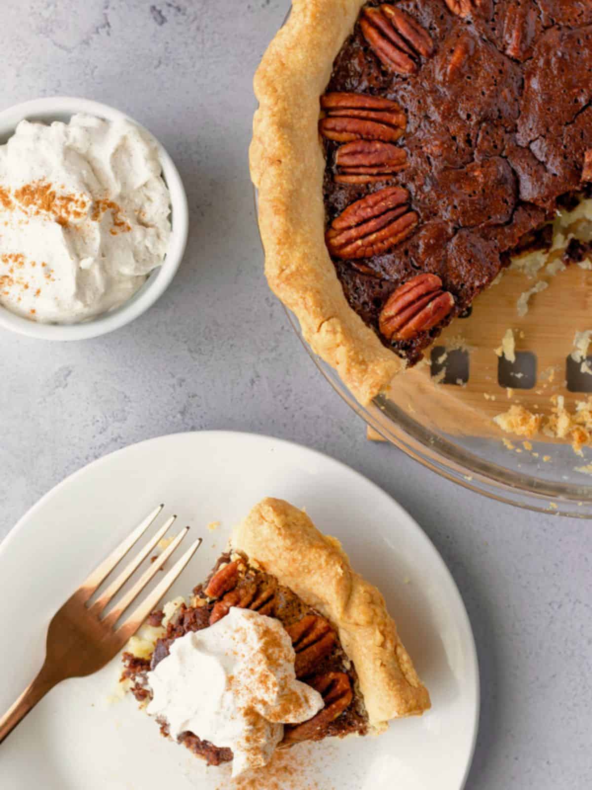 Mexican chocolate pecan pie with a slice on a plate and the rest in the pie dish.