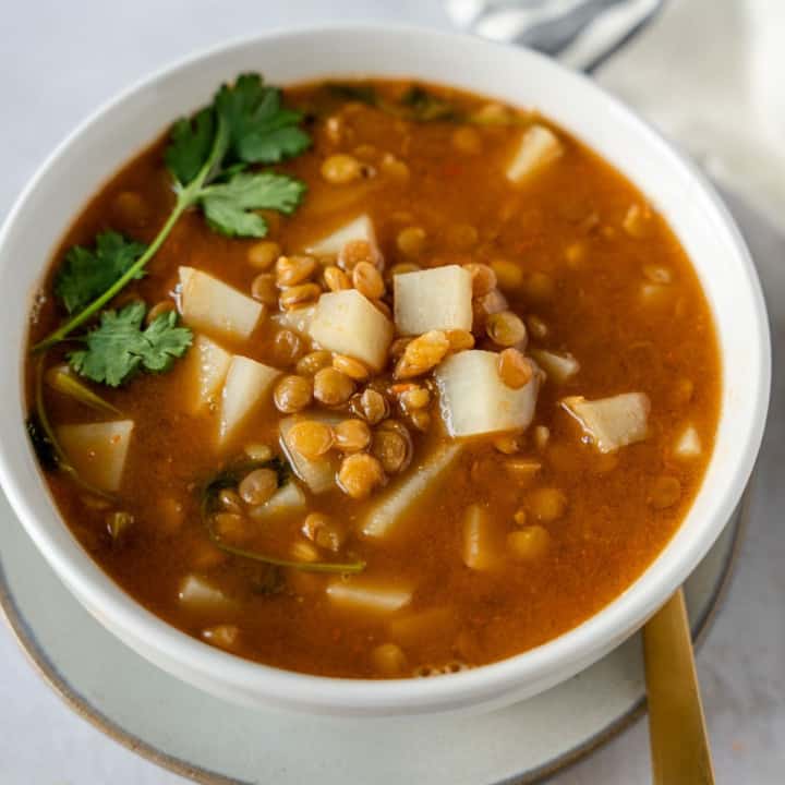 Feature image of Mexican lentil soup in a white bowl.