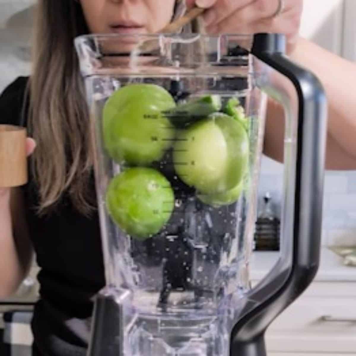 Tomatillos and jalapeno in a blender.