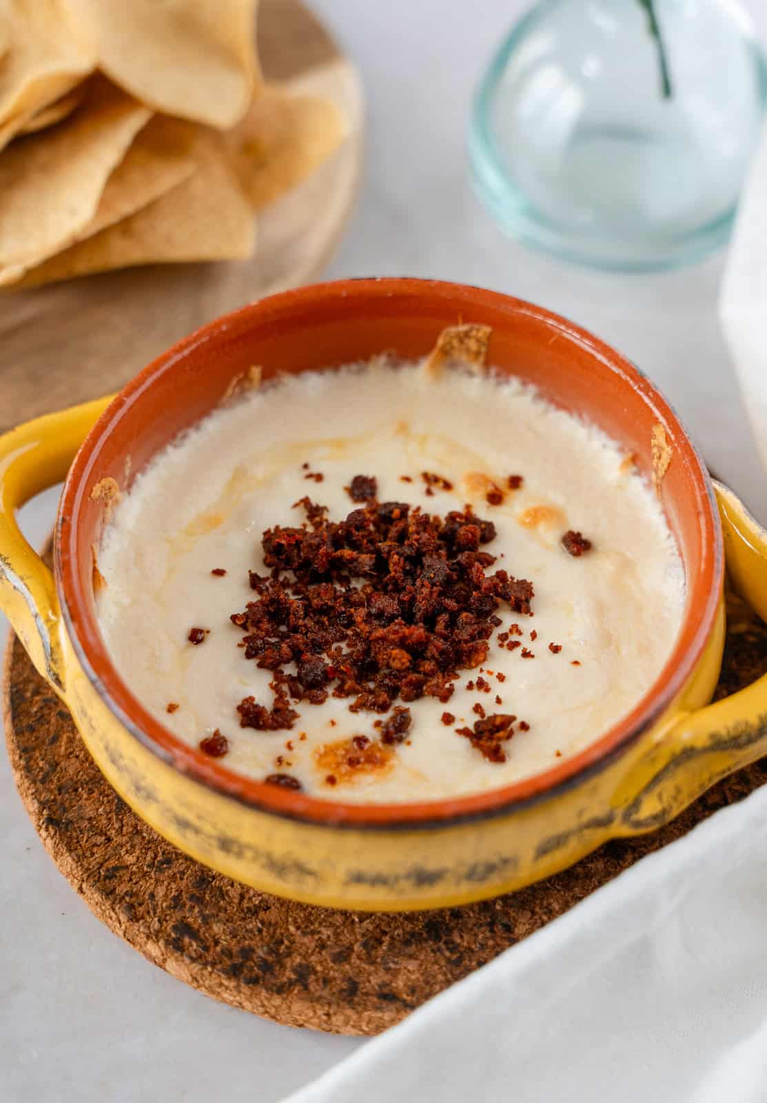 Queso Fundido with chorizo in a yellow ramekin.