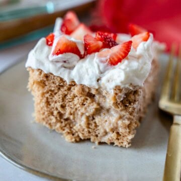 Feature image of a slice of strawberry tres leches cake on a plate.