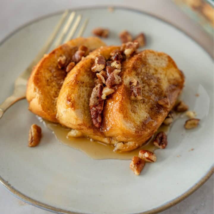 Feature image of bolillo french toast casserole on a plate topped with syrup.