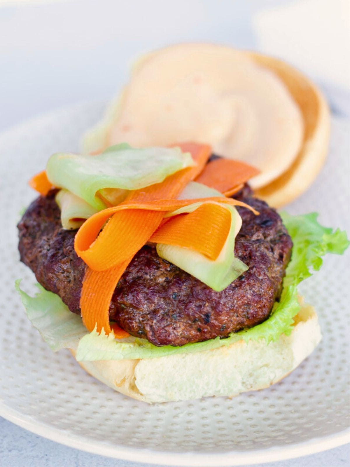 Burger with the top bun removed.