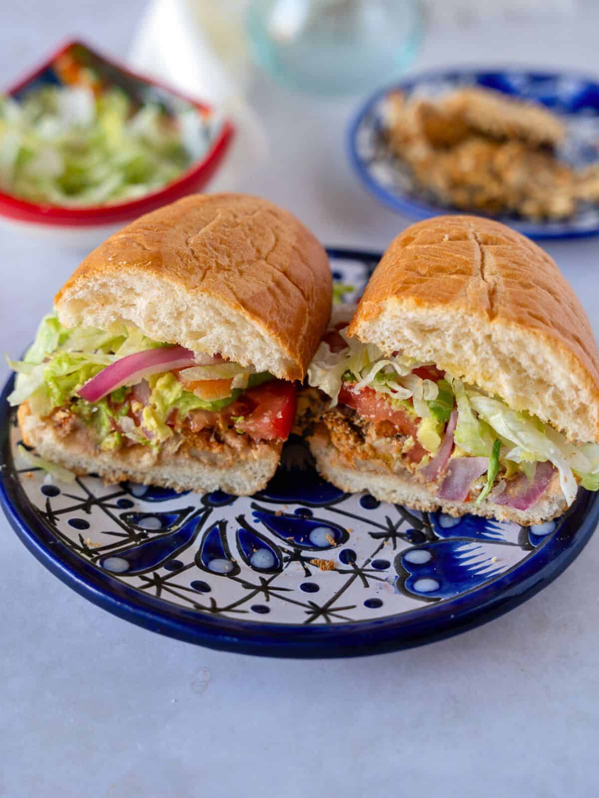 Mushroom torta sliced in half on a blue plate.