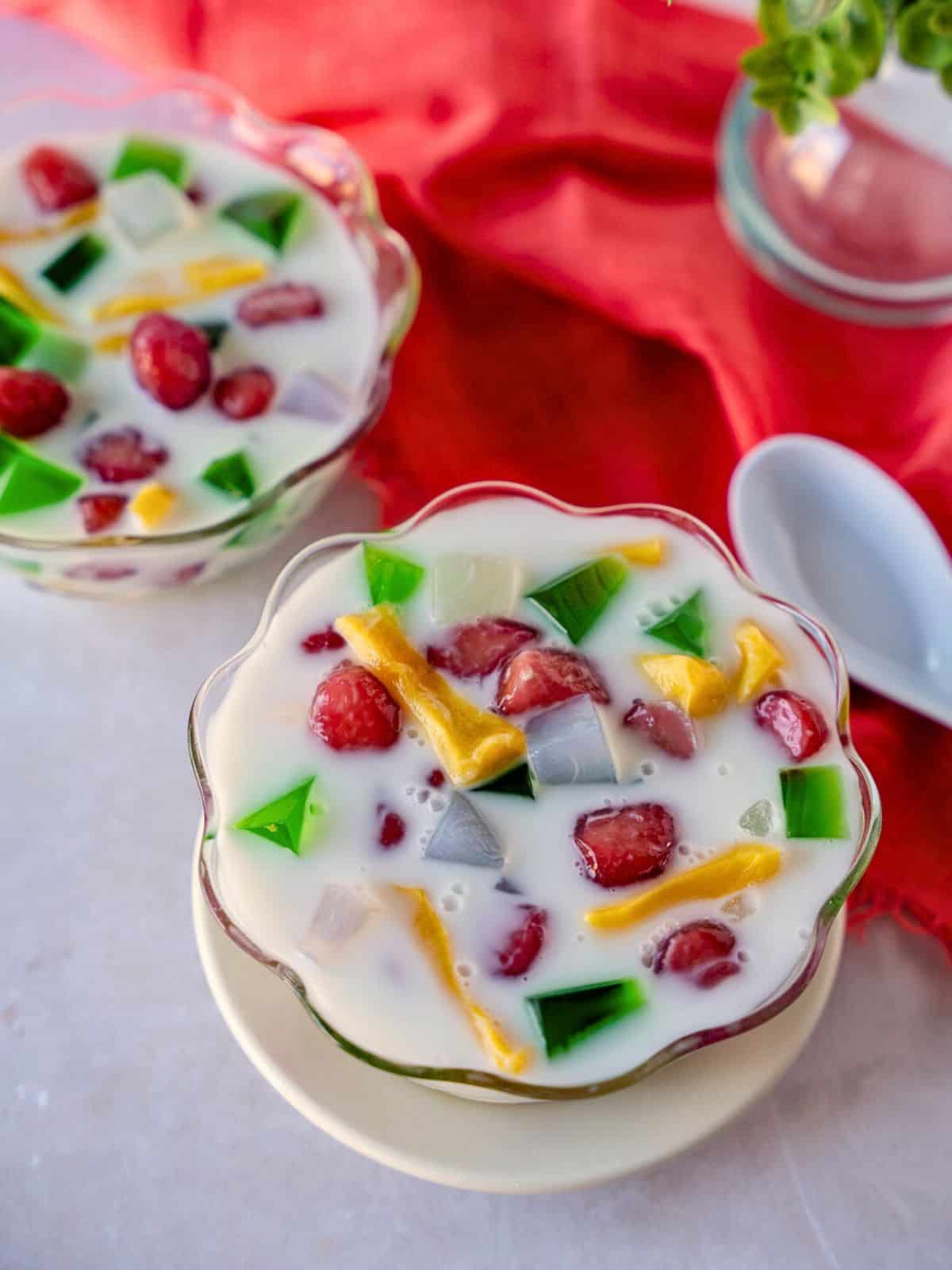 Colorful Thai coconut milk dessert in two bowls with a spoon on the side.