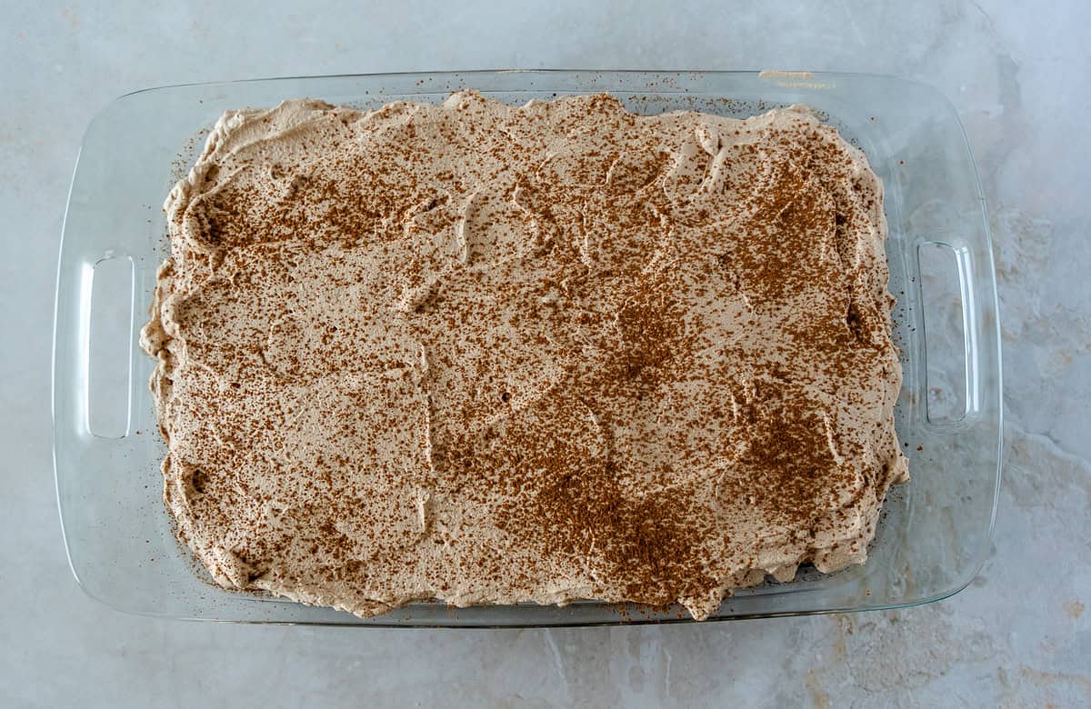 Chocolate tres leches cake in a glass pan.