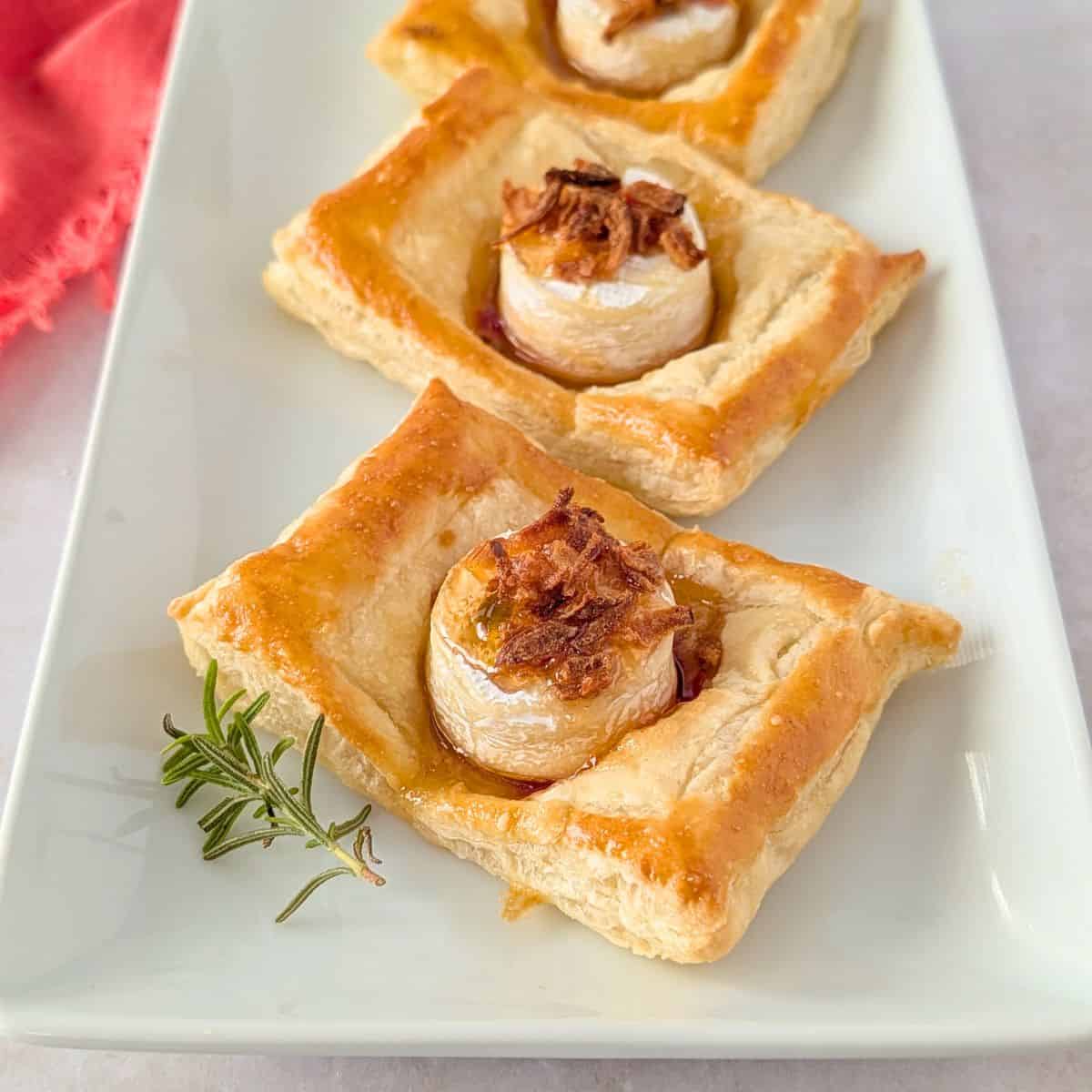 Feature image of brie puff pastry tarts with jelly and fried onions.