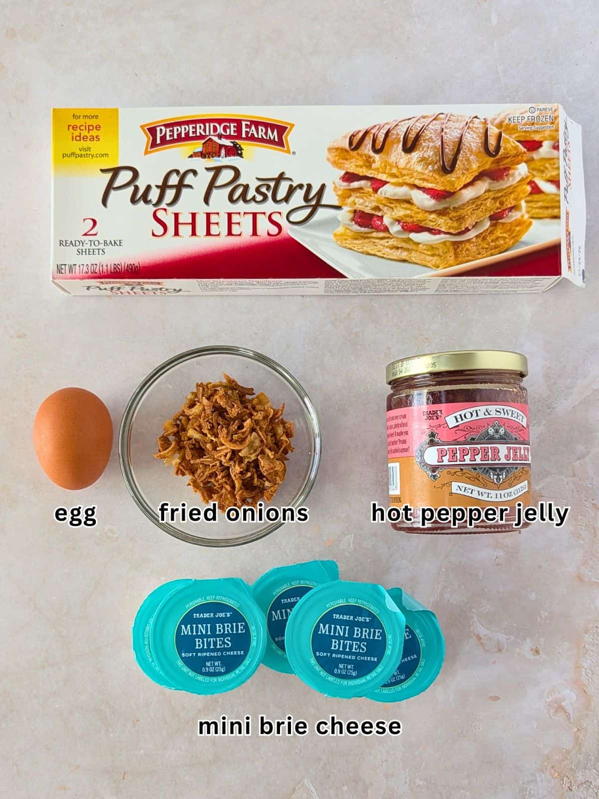 Ingredients with text- puff pastry sheets, egg, fried, onions, hot pepper jelly, mini brie cheese.