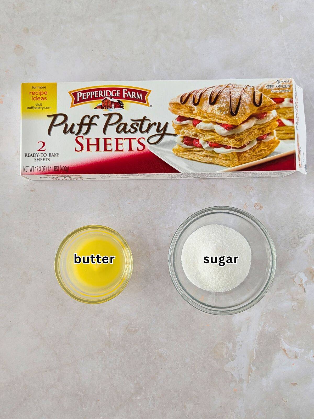 Box of puff pastry sheets, melted butter, and sugar in a bowl.