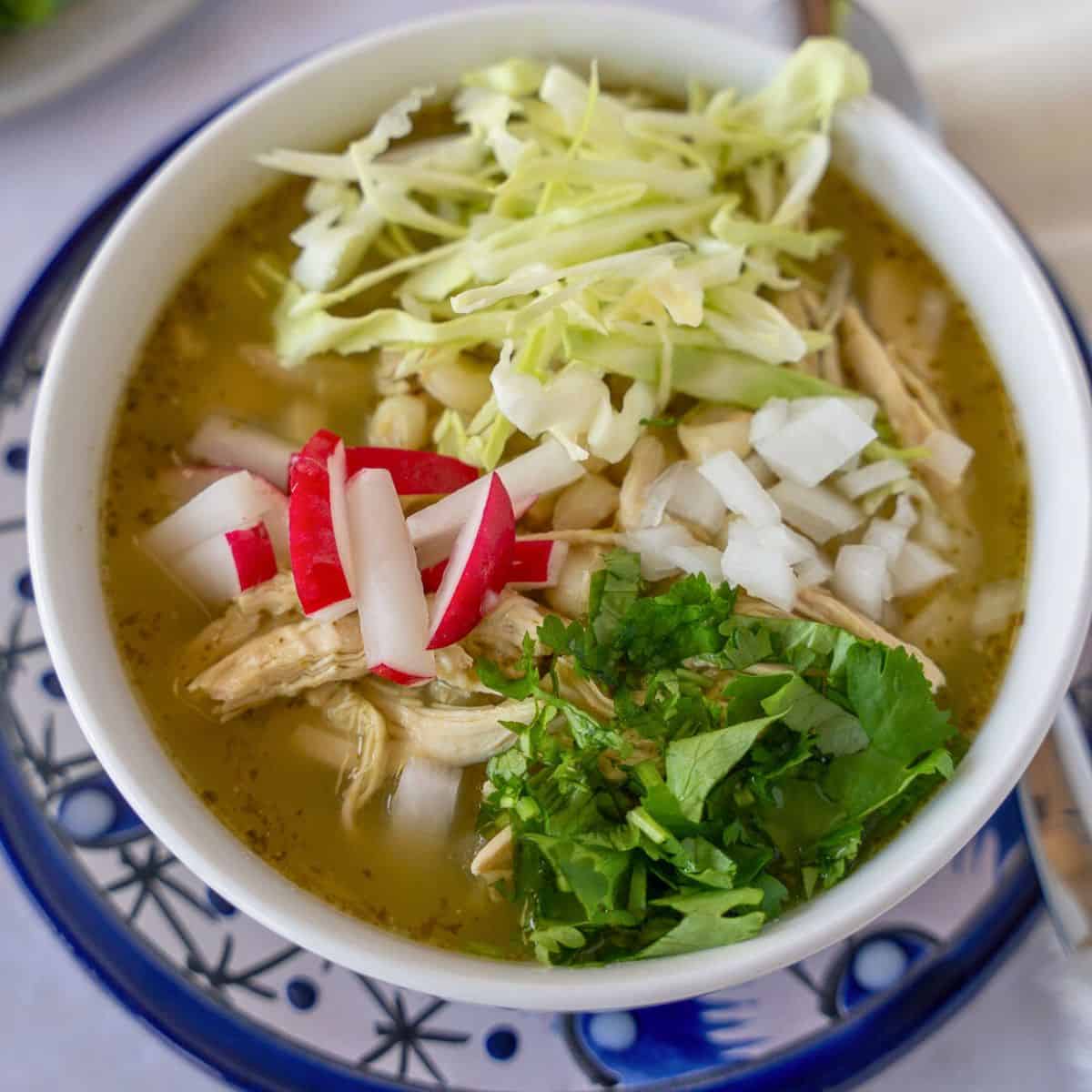 Feature image of pozole verde with chicken and toppings.