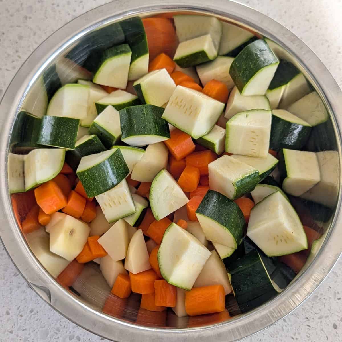 Diced zucchini, carrots, and potatoes in a bowl.