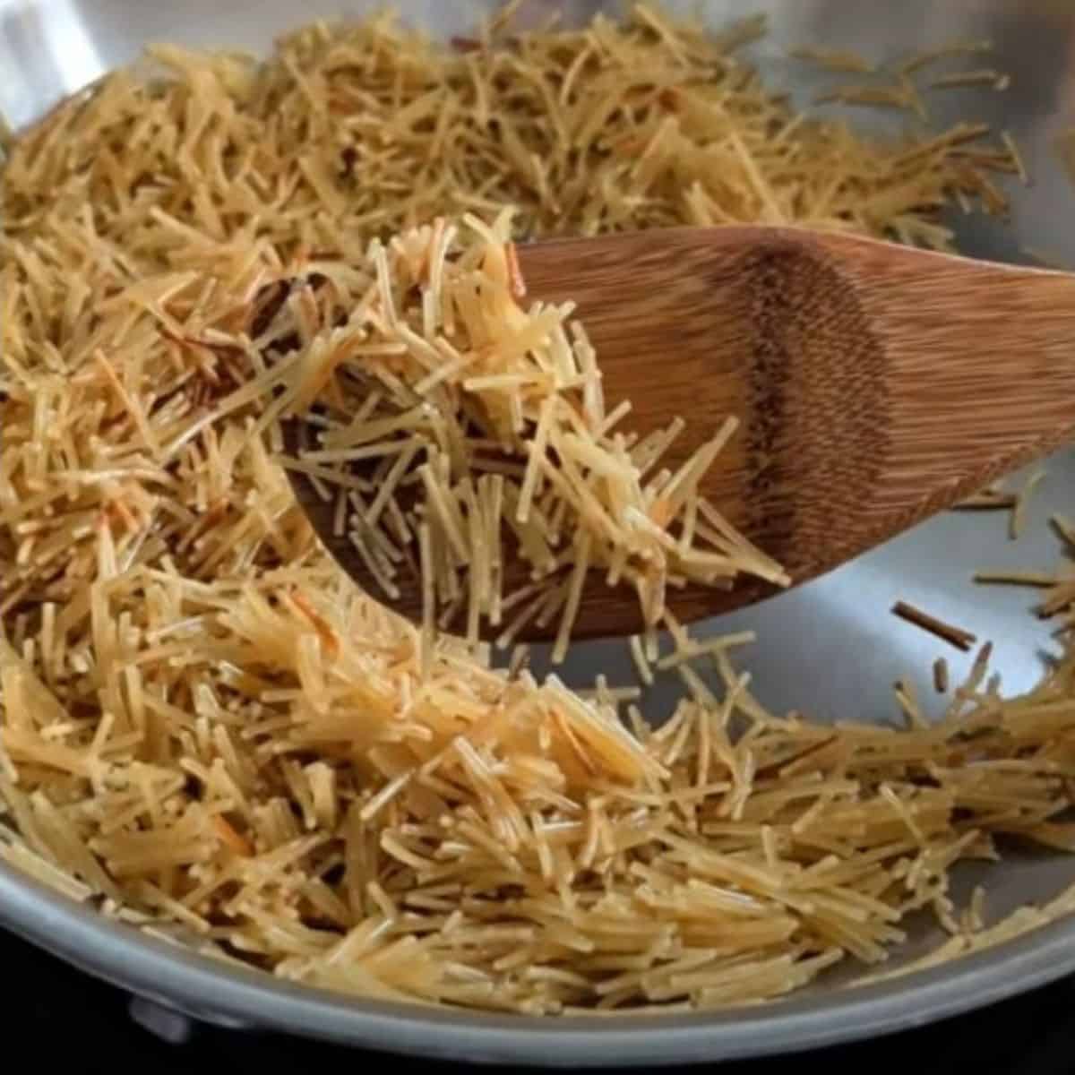 Toasted fideo noodles in a skillet.
