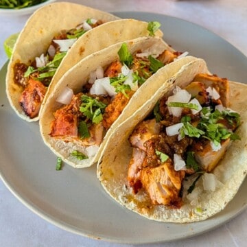 Feature image of pollo asado tacos on a plate.