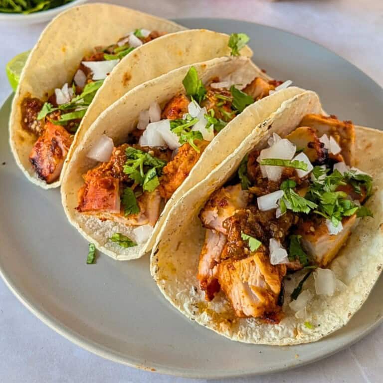 Feature image of pollo asado tacos on a plate.