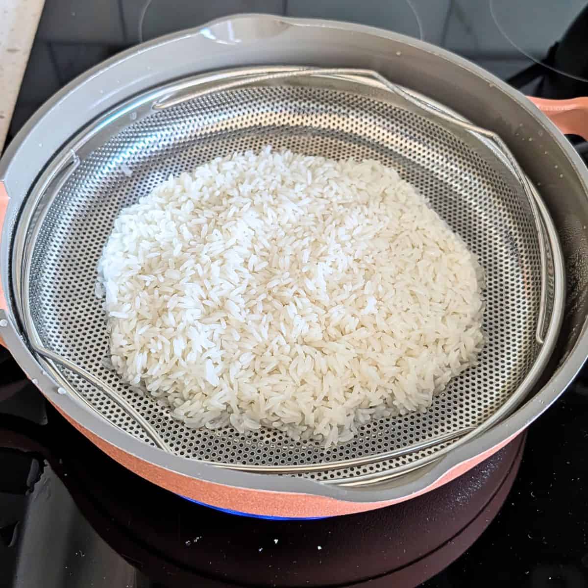 Rice being steamed on a stove.
