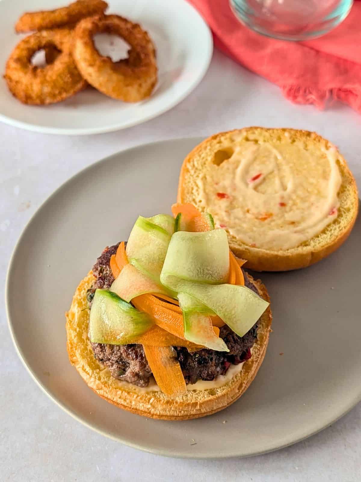 Thai burger topped with carrot and cucumber ribbons.