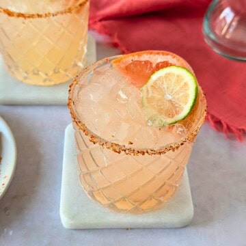 Two Paloma cocktails garnished with grapefruit and lime.