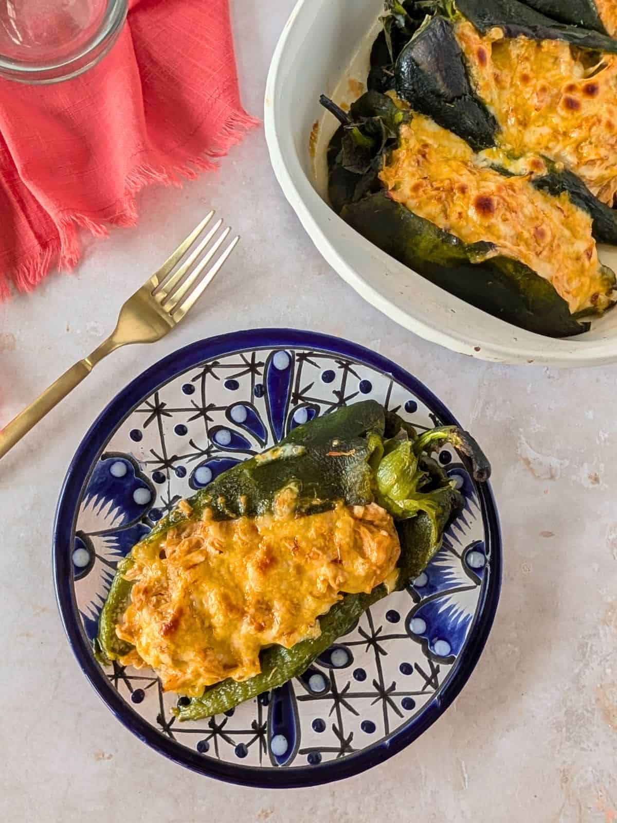 Baked chile relleno stuffed with shredded chicken and topped with melted cheese.