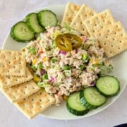 Feature image of Mexican tuna salad on a plate with saltine crackers and cucumbers.