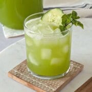 Glass of cucumber lime agua fresca served over ice.