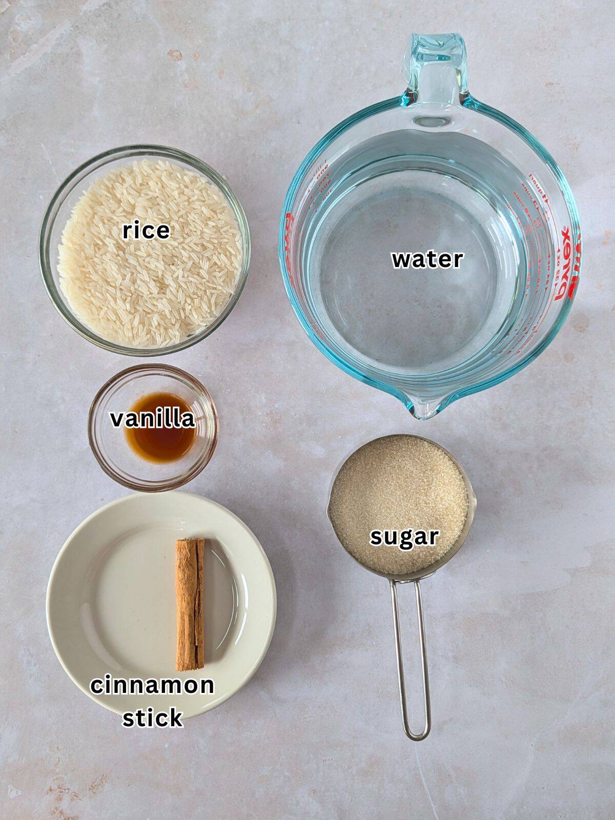 Horchata ingredients. Cinnamon stick, sugar, vanilla, rice and water.
