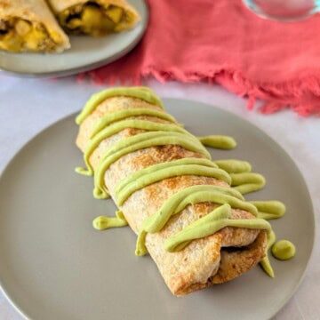 Feature image of chimichanga on a plate with avocado crema drizzle.