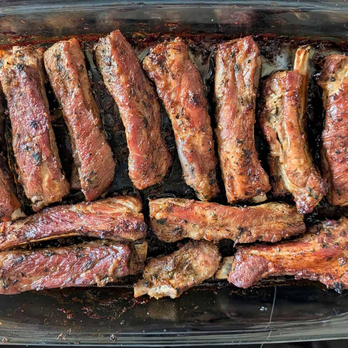 Cooked ribs in a glass baking dish.