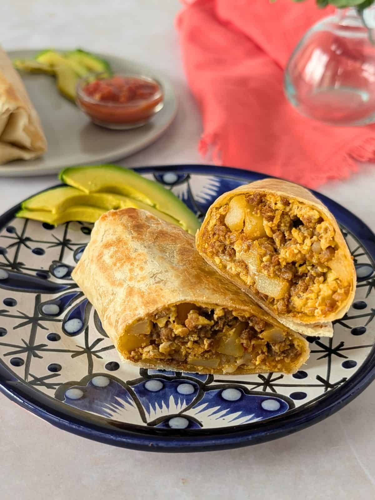 Chorizo burrito sliced in half on a plate.