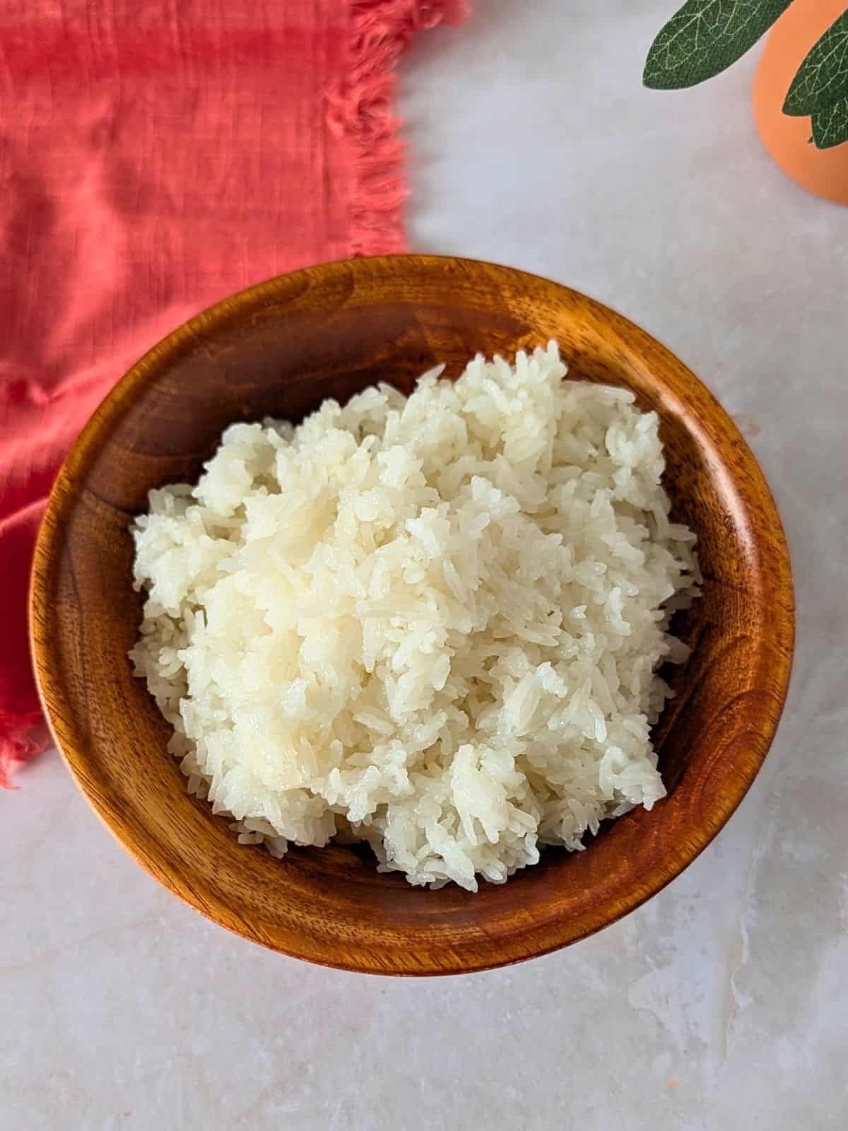 Overhead view of sticky rice in a bamboo bowl.