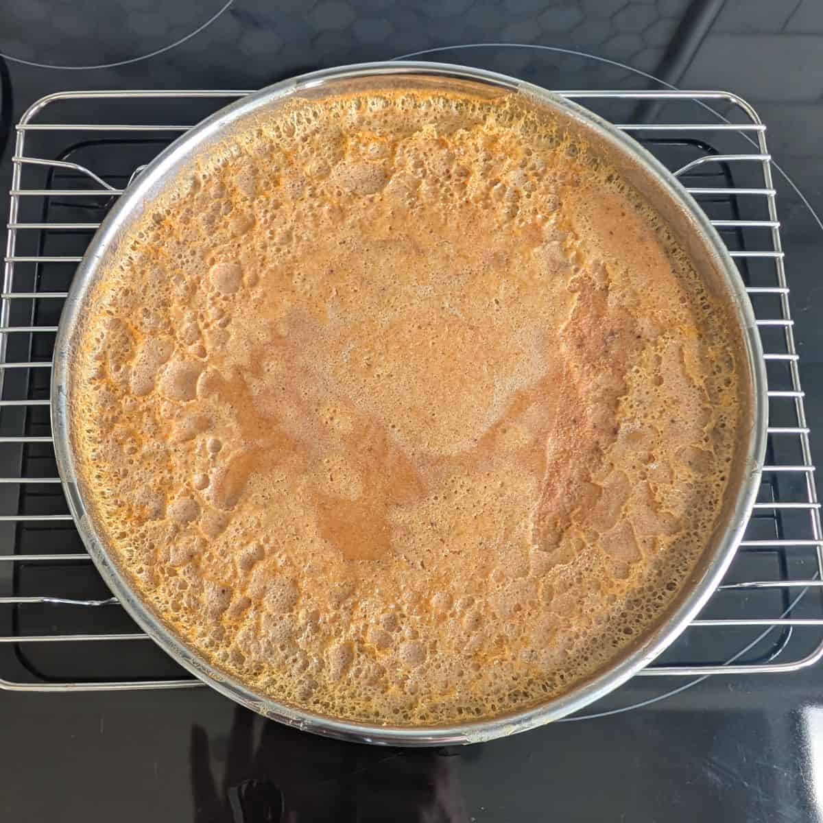 Pumpkin flan in a cake pan, on a cooling rack